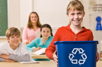 Student carrying recycling bin